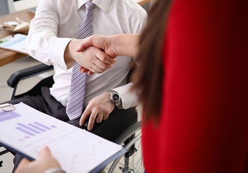 A disabled man shaking hands with his disability - SSDI - attorney.