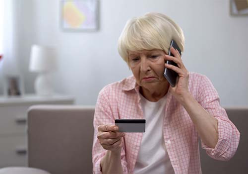 Older Woman On Phone With Bank To Freeze Cards