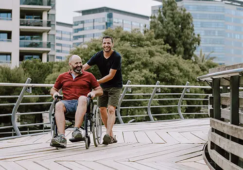 Smiling Man In Wheelchair With A Family Member