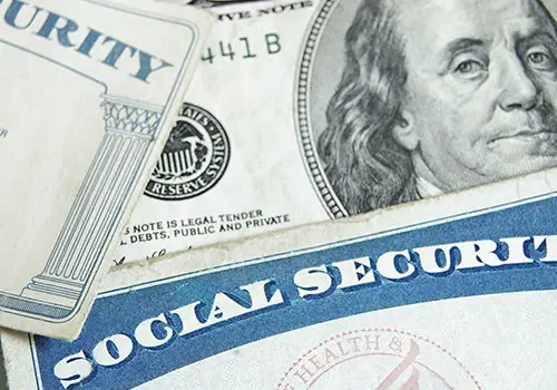 Social Security cards on top of hundred dollar bills.