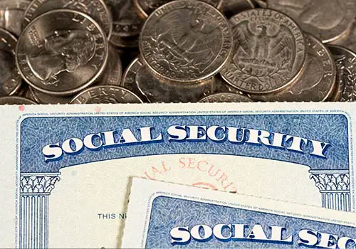Social Security Cards Laid On Top Of Quarters
