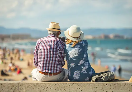 Elderly Couple On The Beach Enjoying Retirement