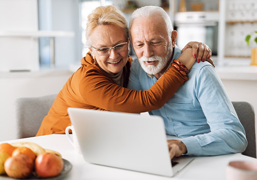 Elderly Couple Using Computer At Home