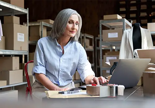 Elderly Woman Using Computer To Run Online Business