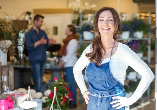 Portrait Of Smiling Female Business Owner Flower Shop Background