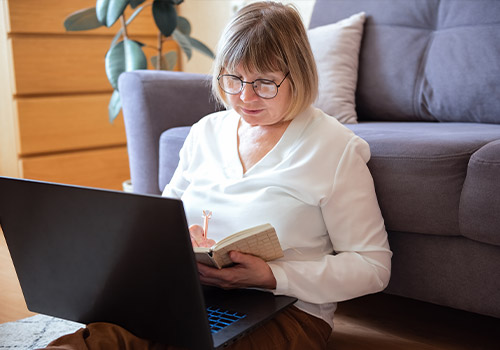 Senior Woman On Laptop Working On Maximizing Spousal Benefits