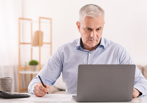 Senior Man Using Laptop To Protect Against Identity Theft