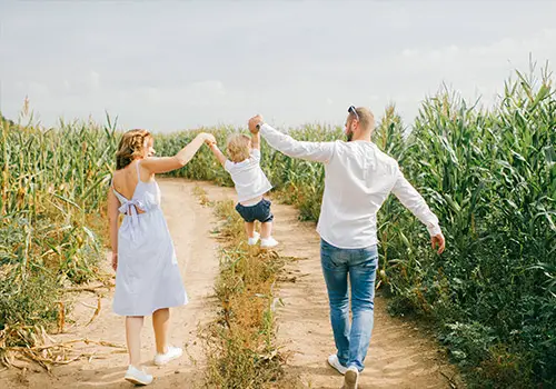 Cheerful Family Of Three In A Cornfield Life Insurance Concept