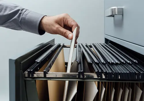 Man Searching For Documents In Filing Cabinet