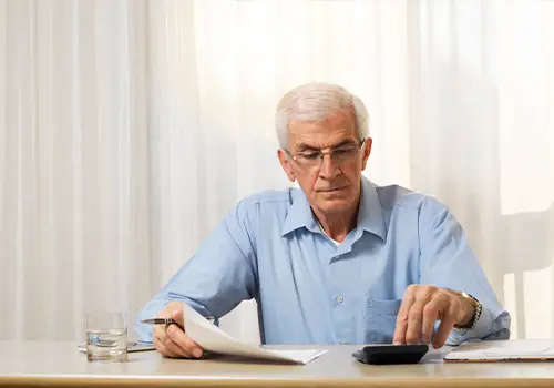 Older Man Calculating Irrevocable Trust Taxes And Setup Costs