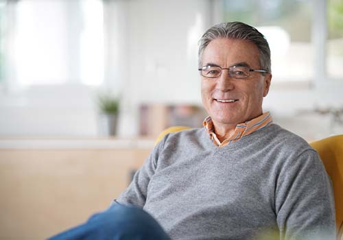 60 Year Old Retired Man Smiling On Couch