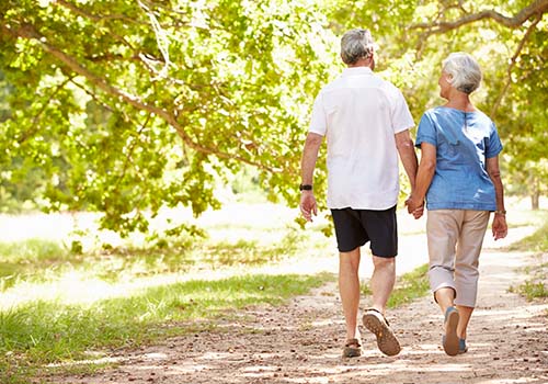 Old Retired Couple Walking Together In Park