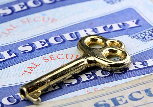 Small golden key on top of social security cards.