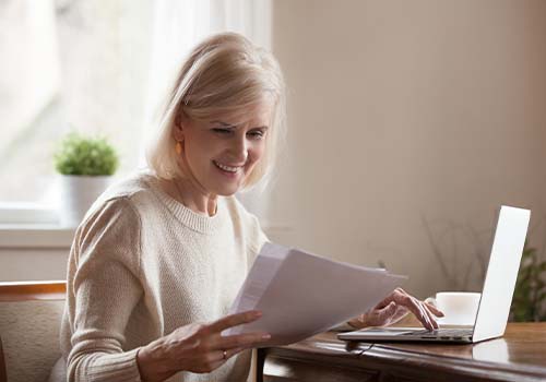 Smiling Old Woman Reading Letter From Medicare