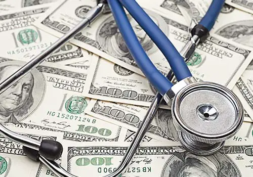Stethoscope On Top Of Heap Of Dollars