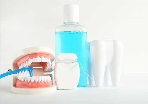 A display conating a bottle of mouthwash, false teeth, a toothbrush, a giant tooth, and dental floss.