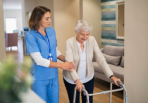 Registered Nurse Assisting Elderly Woman With Physical Therapy