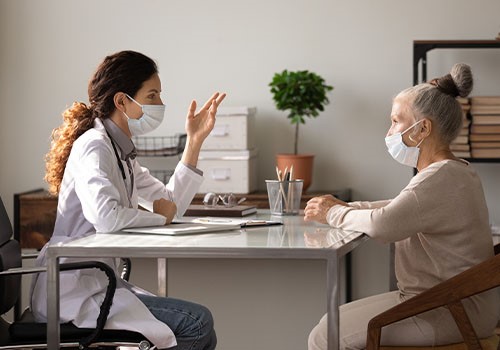 A doctor in conversation with an elderly female patient. 