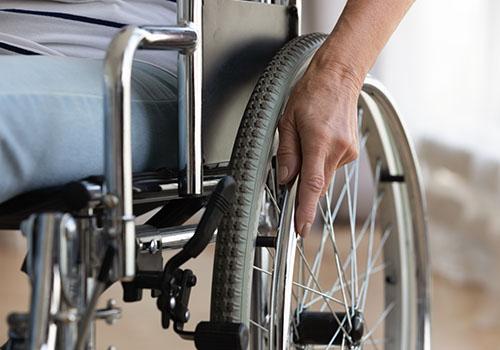 A close-up of a senior handicapped woman sitting in a wheelchair while in a nursing home.