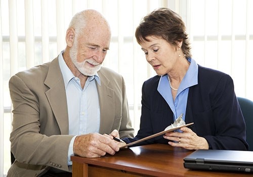 An elderly man discussing his SSI overpayment appeal with his attorney.